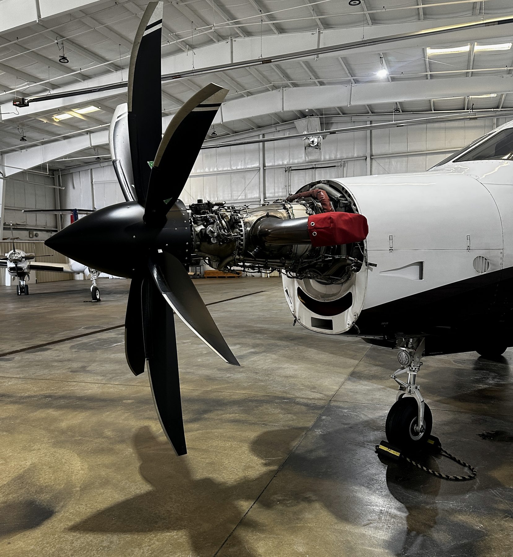 Five-blade turboprop with the cowling open for maintenance in a hangar