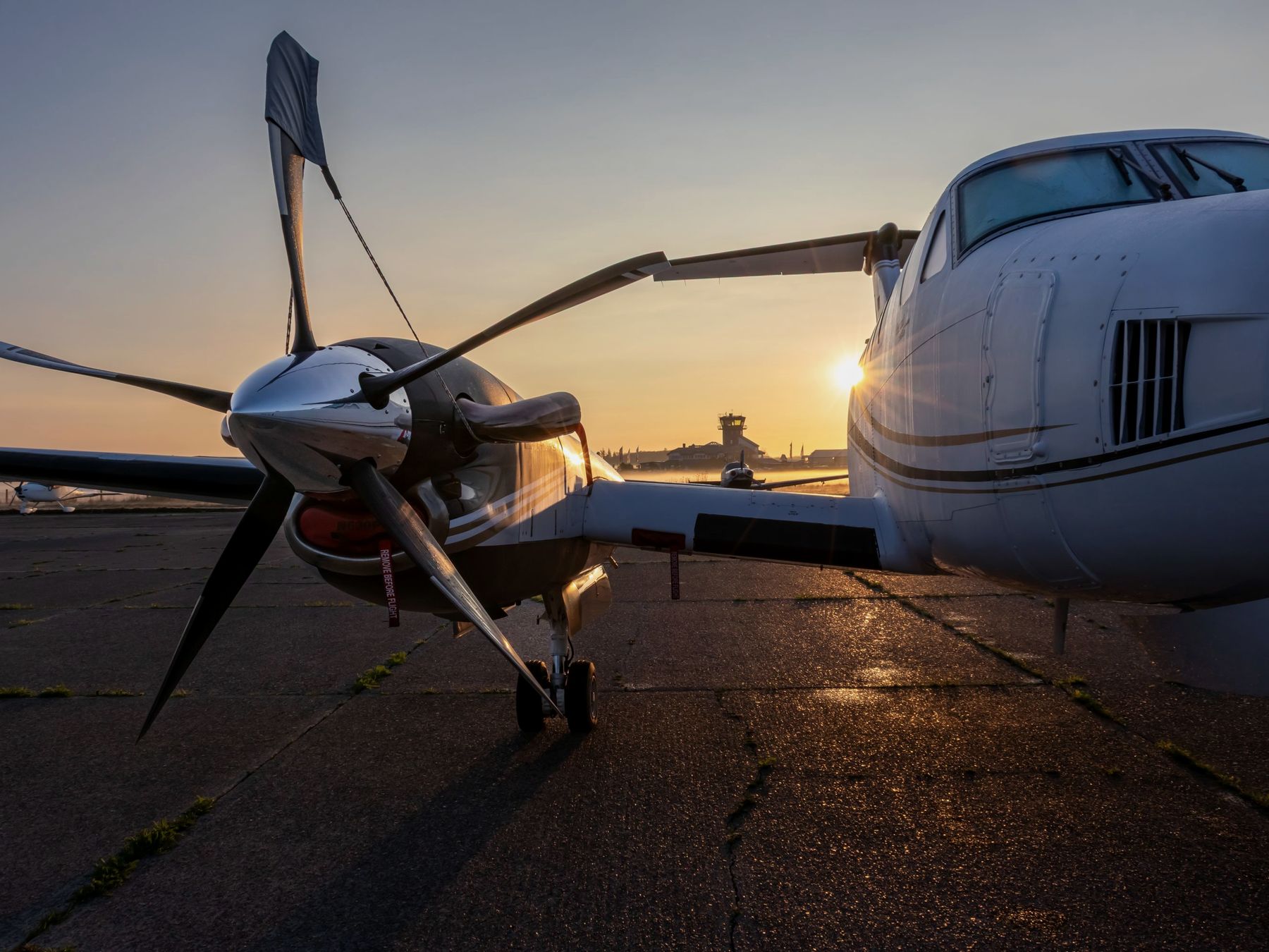 Turboprop propeller and the nose of a second aircraft on the ramp at sunrise